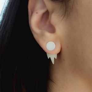 Puede incluir: Un par de pendientes de cartílago blanco falso con una parte superior redonda y un diseño de carámbano que gotea.