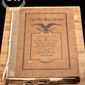 May include: A brown leather-bound book titled "The Stars and Stripes: A Complete File of The Stars and Stripes, The Official Newspaper of the American Expeditionary Forces, Printed in France from February 8th 1918 to June 13th 1919".