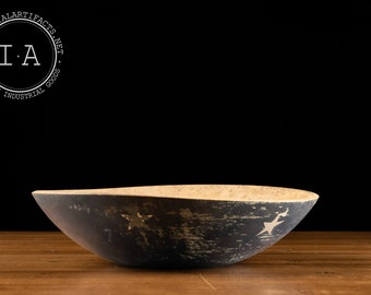 May include: A vintage, hand-carved wooden bowl with a dark exterior and a light interior. The bowl features a star design and is set against a dark background. The logo "INDUSTRIALARTIFACTS.NET" is in the upper left corner.