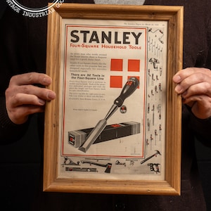 May include: A vintage advertisement for Stanley Four-Square Household Tools. The ad features a close-up of a chisel with the Stanley logo and the text "There are 32 Tools in the Four-Square Line". The ad also includes a variety of other tools, including a hammer, saw, and plane.