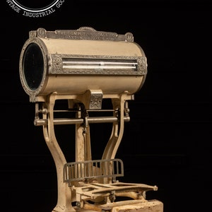 May include: Antique white and silver computing scale with the text "THE COMPUTING SCALE CO. DAYTON, OHIO, U.S.A." on the front. The scale has a round, glass-covered display and a platform for weighing items.
