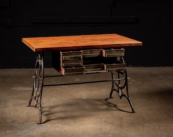 May include: A handcrafted wooden desk with a reddish-brown tabletop and multiple small drawers. The desk features a vintage-style metal base with ornate, curved legs. The desk is a unique piece of furniture.