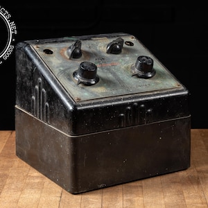 May include: A black metal box with four knobs and a green metal panel. The panel has the text "Automatic" and "Transformer" printed on it.