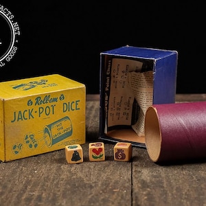 May include: Vintage Roll'em Jack-Pot Dice game set. The yellow box features the game's name and graphics. Includes dice, a blue box, and a maroon tube. The dice have symbols like a bell, a heart, and a dollar sign. The game is displayed on a wooden surface.
