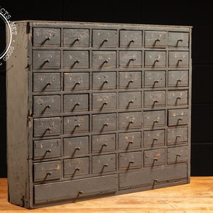 May include: A vintage wooden cabinet with 36 drawers, painted a dark gray color. The drawers have metal pulls and are numbered. The cabinet is in good condition with some signs of wear and tear.