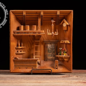 May include: A detailed wooden diorama depicting a rustic interior scene. The miniature artwork features shelves, a ladder, a small clock, and a window with a landscape. The piece is crafted from light-colored wood and has a vintage aesthetic.