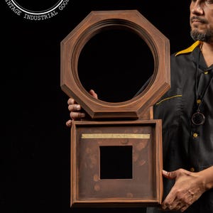 May include: Two antique wooden frames, one octagonal and one square, are held against a black background. The octagonal frame has a circular opening, while the square frame has a smaller square opening. The square frame has text that reads "FACE & SIDES".