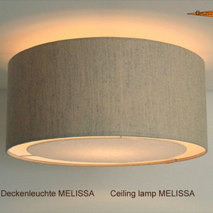 May include: A beige fabric ceiling lamp with a white inner shade. The lamp is labeled "Ceiling lamp MELISSA".