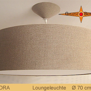 Op de afbeelding: Een hanglamp met een beige stoffen trompetvormige lampenkap en een witte binnenbekleding. De lamp heeft een diameter van 70 cm. De merknaam "GRUZDZ BERLIN" is zichtbaar in de rechterbovenhoek van de afbeelding.
