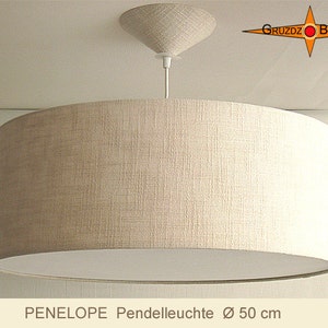 Puede incluir: Una lámpara colgante de tela beige con una pantalla interior blanca. La luz es redonda y mide 50 cm de diámetro. La luz está etiquetada como "PENELOPE Pendelleuchte Ø 50 cm".