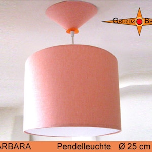 May include: A pink fabric pendant light with a white inner shade. The light is suspended from a white ceiling with a pink, cone-shaped top. The light is 25 inches in diameter.
