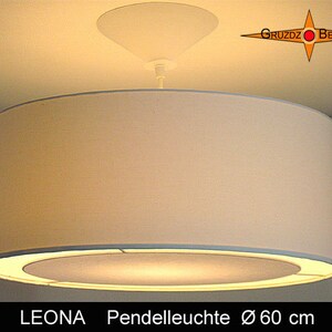 Könnte beinhalten: Eine weiße runde Pendelleuchte mit einem Durchmesser von 60 cm. Die Leuchte hat einen weißen Stoffschirm und einen weißen Metallrahmen. Die Leuchte hängt von der Decke.