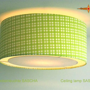 May include: A green and white checkered ceiling lamp with a white inner shade. The lamp is labeled "Ceiling lamp SASCHA".