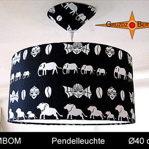 May include: Black and white pendant light with a fabric shade featuring a repeating pattern of elephants, coffee beans, and stylized faces. The shade is 40 inches in diameter.