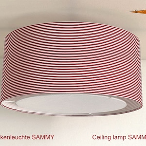 Op de afbeelding: Een rood-wit gestreepte plafondlamp met een witte diffuser. De lamp heet "SAMMY".