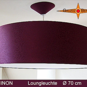 May include: A large, round, burgundy fabric lampshade with a white inner lining. The lampshade is 70 cm in diameter and has a subtle swirl pattern. The lampshade is hanging from a white ceiling fixture.