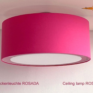 Könnte beinhalten: Eine rosafarbene Deckenleuchte mit einem weißen Innenschirm. Die Lampe ist mit "Deckenleuchte ROSADA" und "Ceiling lamp ROSADA" beschriftet.