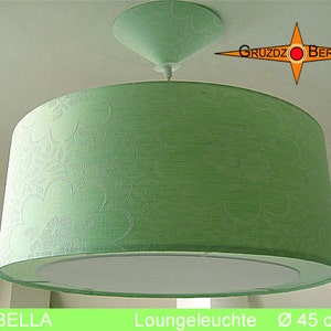 Könnte beinhalten: Ein grüner Lampenschirm aus Stoff mit weißem Blumenmuster. Der Lampenschirm hat einen Durchmesser von 45 cm und eine weiße Innenverkleidung. Der Lampenschirm hängt an einer Deckenleuchte.