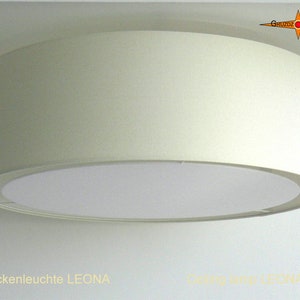 Könnte beinhalten: Eine weiße Deckenleuchte mit einem runden, weißen Stoffschirm. Die Lampe ist mit "Deckenleuchte LEONA" beschriftet.