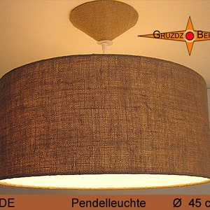 May include: A brown fabric pendant light with a diameter of 45 inches. The light is hanging from a ceiling and has a simple design.