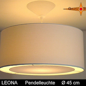 May include: White fabric pendant light with a round, white shade. The shade has a thin, silver rim and a white, circular light source. The light is hanging from a white ceiling fixture. The light is labeled "LEONA Pendelleuchte Ø 45 cm".