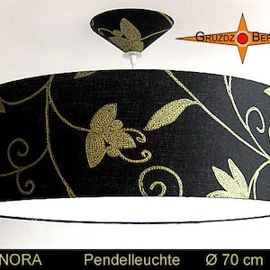 Peut inclure: Luminaire suspendu avec un motif floral noir et or, d'un diamètre de 70 cm. L'abat-jour est en tissu et a un intérieur blanc.