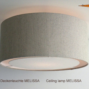 Könnte beinhalten: Eine Deckenleuchte aus beigefarbenem Stoff mit einem weißen Diffusor. Die Leuchte ist mit "Deckenleuchte MELISSA" beschriftet.