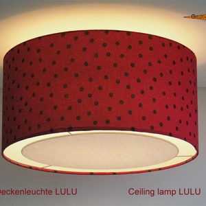 Könnte beinhalten: Eine rote Deckenleuchte mit schwarzen Punkten. Der Lampenschirm ist rund und hat eine weiße Innenverkleidung. Der Text "Ceiling lamp LULU" steht unter der Lampe.