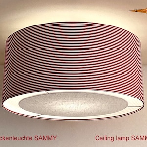 Könnte beinhalten: Eine rote Deckenleuchte mit einem weißen Stoffschirm. Die Leuchte ist mit "Deckenleuchte SAMMY" beschriftet.