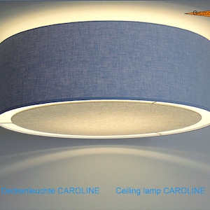 May include: A blue fabric ceiling lamp with a white inner ring. The lamp is labeled "Ceiling lamp CAROLINE".