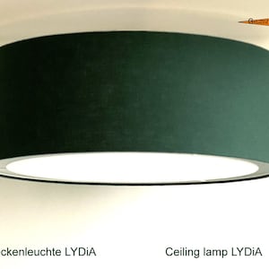 May include: A dark green fabric ceiling lamp with a white inner shade. The lamp is labeled "Ceiling lamp LYDIA".