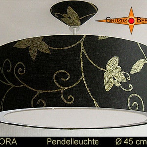 May include: Black and gold pendant light with a floral pattern. The shade is 45 inches in diameter. The light is labeled "Lenora" and "Pendeleuchte".
