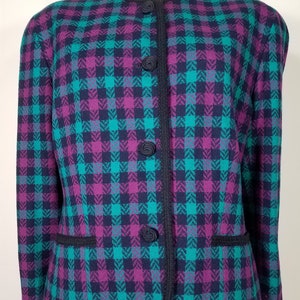 May include: A black and teal plaid blazer with a black trim and buttons. The blazer has a classic fit and a single-breasted closure.