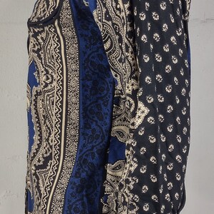 May include: A blue and cream paisley patterned long-sleeve shirt with a button-up collar.