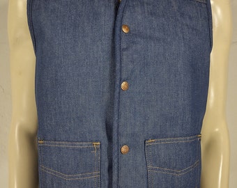 May include: A blue denim vest with a V-neck, featuring two front pockets and four copper-colored buttons. The vest has a classic design with visible stitching and a small label near the pocket.