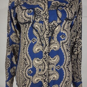 May include: A blue long-sleeved button-down shirt with a paisley pattern in black and cream.