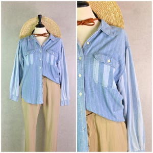 May include: Light blue denim shirt with vertical white stripes on the sleeves and pockets. The shirt has a button-down front and two chest pockets. The outfit includes tan pants and a straw hat.