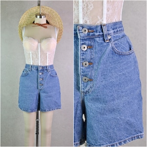 Könnte beinhalten: Hellblaue Jeansshorts mit Knopfleiste vorne. Die Shorts haben eine hohe Taille und Taschen. Ein Strohhut und ein weißes Spitzenkorsett sind ebenfalls sichtbar.