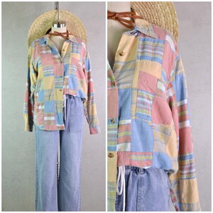 May include: A patchwork button-down shirt in pastel colors of pink, yellow, and blue, paired with light blue jeans. The shirt features a collared neckline and long sleeves. A straw hat and brown necklace are also visible.