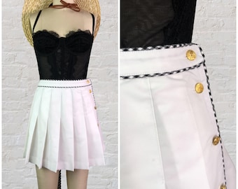 lizsport white pleated mini tennis skirt with gold racket buttons and black/white gingham trim . 29" waist . 90s vintage