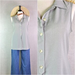 Puede incluir: Una camisa sin mangas de color gris claro con botones y cuello, combinada con pantalones vaqueros azules de pernera ancha. La camisa tiene una fila de botones en la parte delantera. Un sombrero de paja está sobre una cabeza de maniquí.