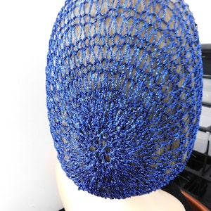 May include: A blue, open-weave hair net. The net is made of a shiny, metallic thread, and it covers the top and back of the head. The net is a vibrant shade of blue, and it appears to be new.