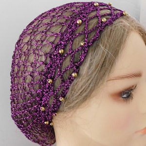 May include: A purple, net-like hair covering with gold-colored beads. The head covering is made of a shiny, metallic material. The netting is designed in a diamond pattern. The beads are evenly spaced along the top edge of the head covering.
