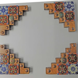 May include: Four wooden corner pieces with a layered design. Each piece is decorated with colorful, patterned tiles and metal accents.