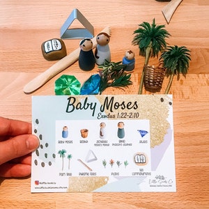 May include: A printable card with illustrations of wooden figurines and objects related to the story of Baby Moses from the Bible. The card includes the text "Baby Moses Exodus 1:22-2:10".