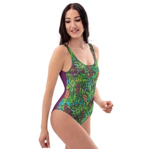 May include: A one-piece swimsuit featuring a vibrant tropical print. The swimsuit showcases a pattern of green leaves and colorful pineapples against a dark purple background. The sides of the swimsuit are solid purple.