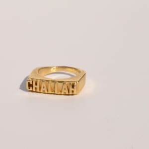 May include: Gold ring with the word "CHALLAH" embossed on the front.