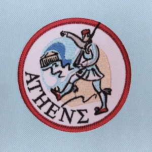 May include: A red, white, and blue embroidered patch with a person riding a horse. The patch says "ATHENE" in a cursive font.