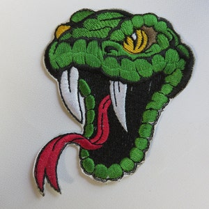 May include: Green and black embroidered snake patch with a red tongue and a yellow eye. The snake's mouth is open and its fangs are visible.