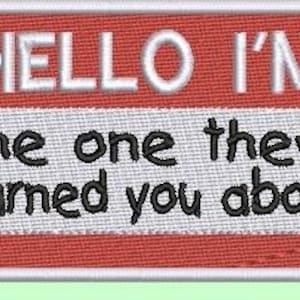 May include: Embroidered patch with a red and white name tag design. The text "HELLO I'M" is at the top, with "the one they warned you about" below. The patch has a white border.